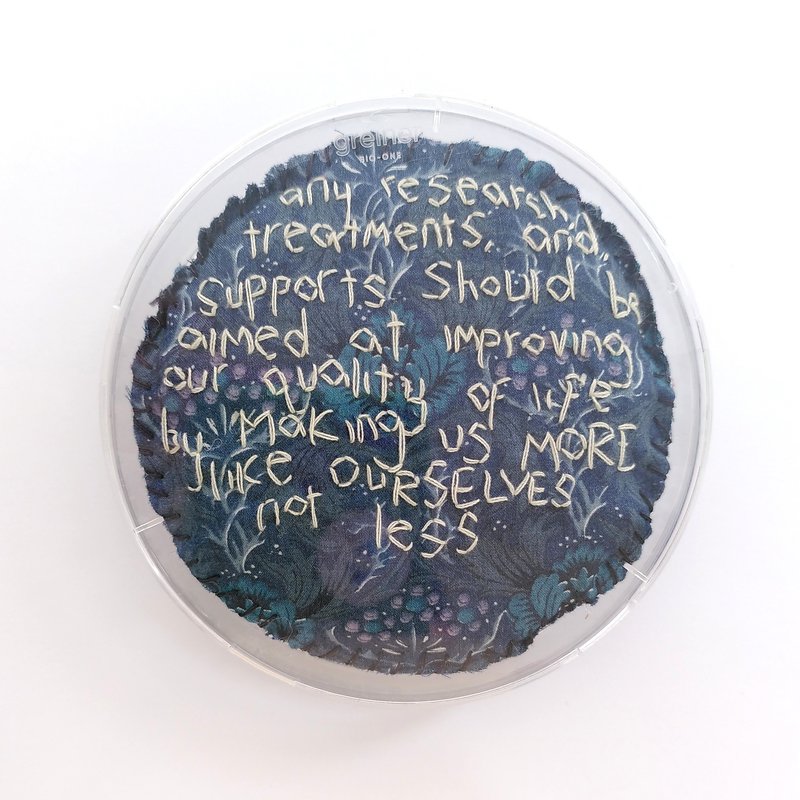 Photo of one petri dish that says &#x27;any research treatments and supports should be aimed at improving our quality of life by making us more like ourselves not less