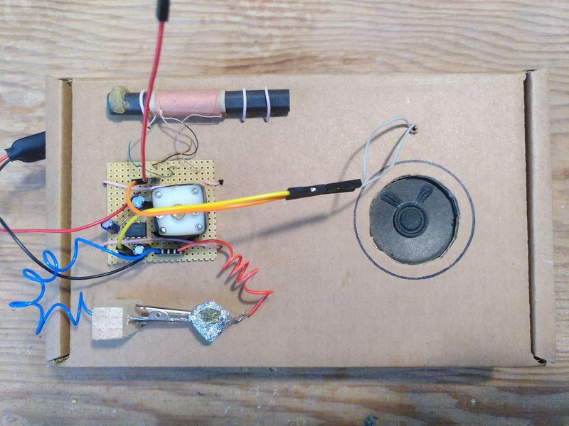 A radio using a pyrite crystal as a diode, with an otherwise normal circuit board (stripboard) and coil, speaker all mounted on/in a cardboard box