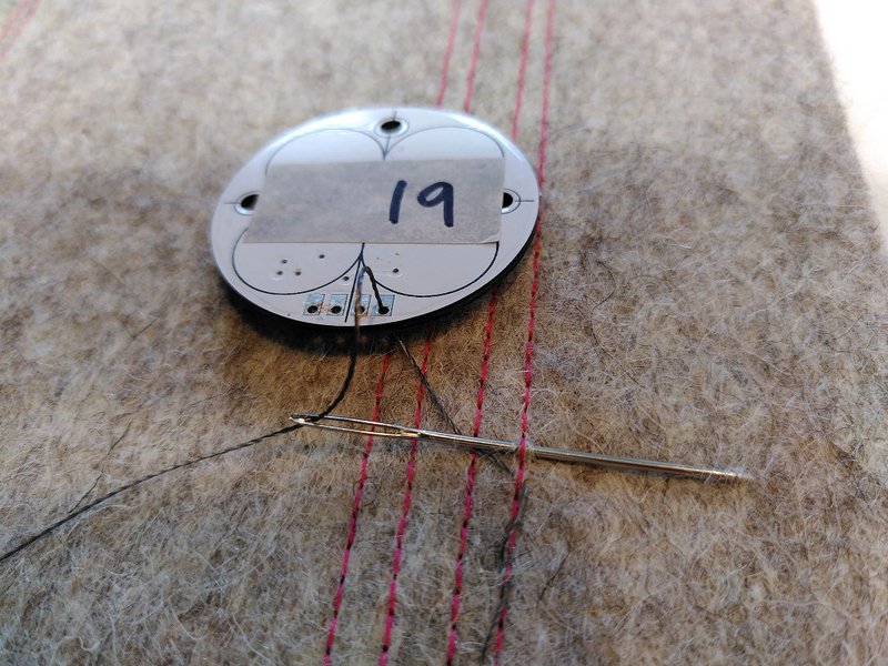 One of the sensors being stitched into place with a needle