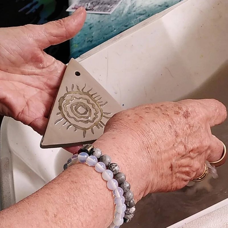 Two hands washing a just made tile