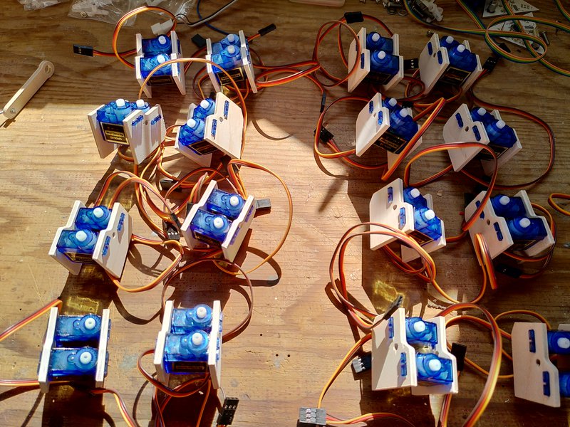 16 pairs of servos sandwiched between their wooden housings ready to make into 8 spike protein mechanisms