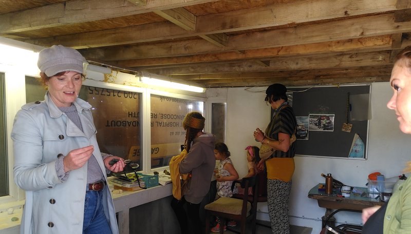 Four people examine a mineral sample under a microscope in the background while two people discuss another find in the foreground.