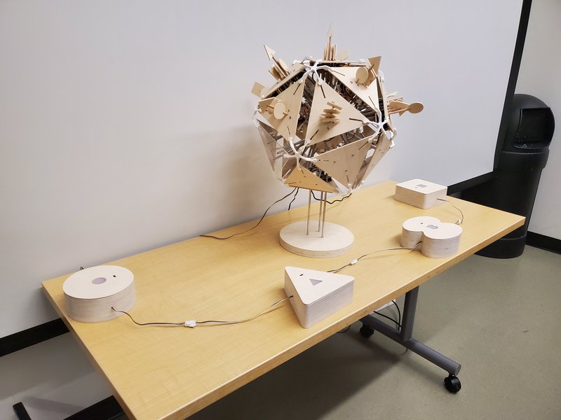 Wood virus structure on a table, with four wood sensor shapes surrounding it